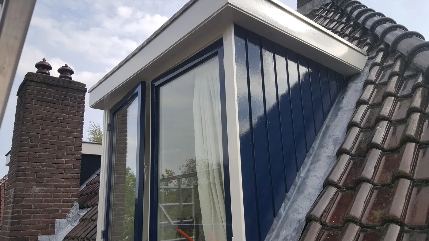 Dakkapel met donkerblauwe verticale delen en lichte boeiboorden na het werk — schilderwerk in Assen door BontBouw
