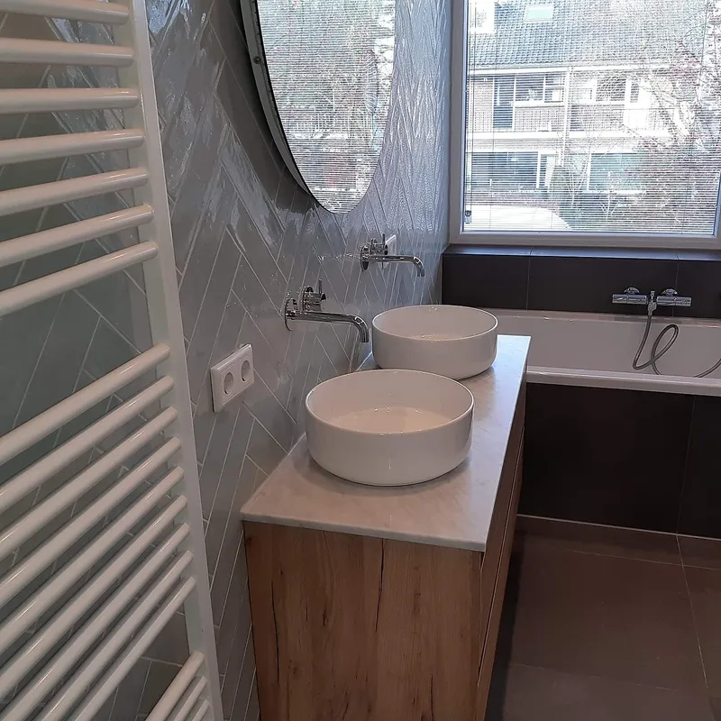 Dubbele wastafel naast het ligbad — badkamerrenovatie in Coendersborg door BontBouw
