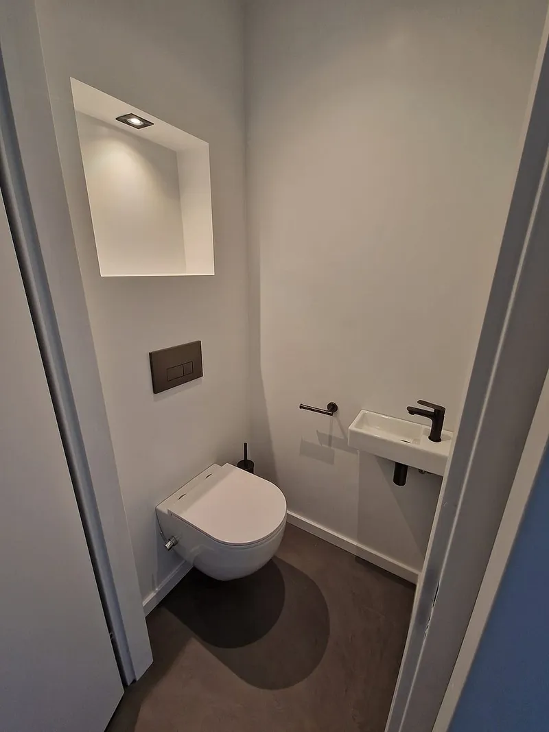 Hangend toilet met zwarte bedieningsplaat — toiletrenovatie in Roden door BontBouw