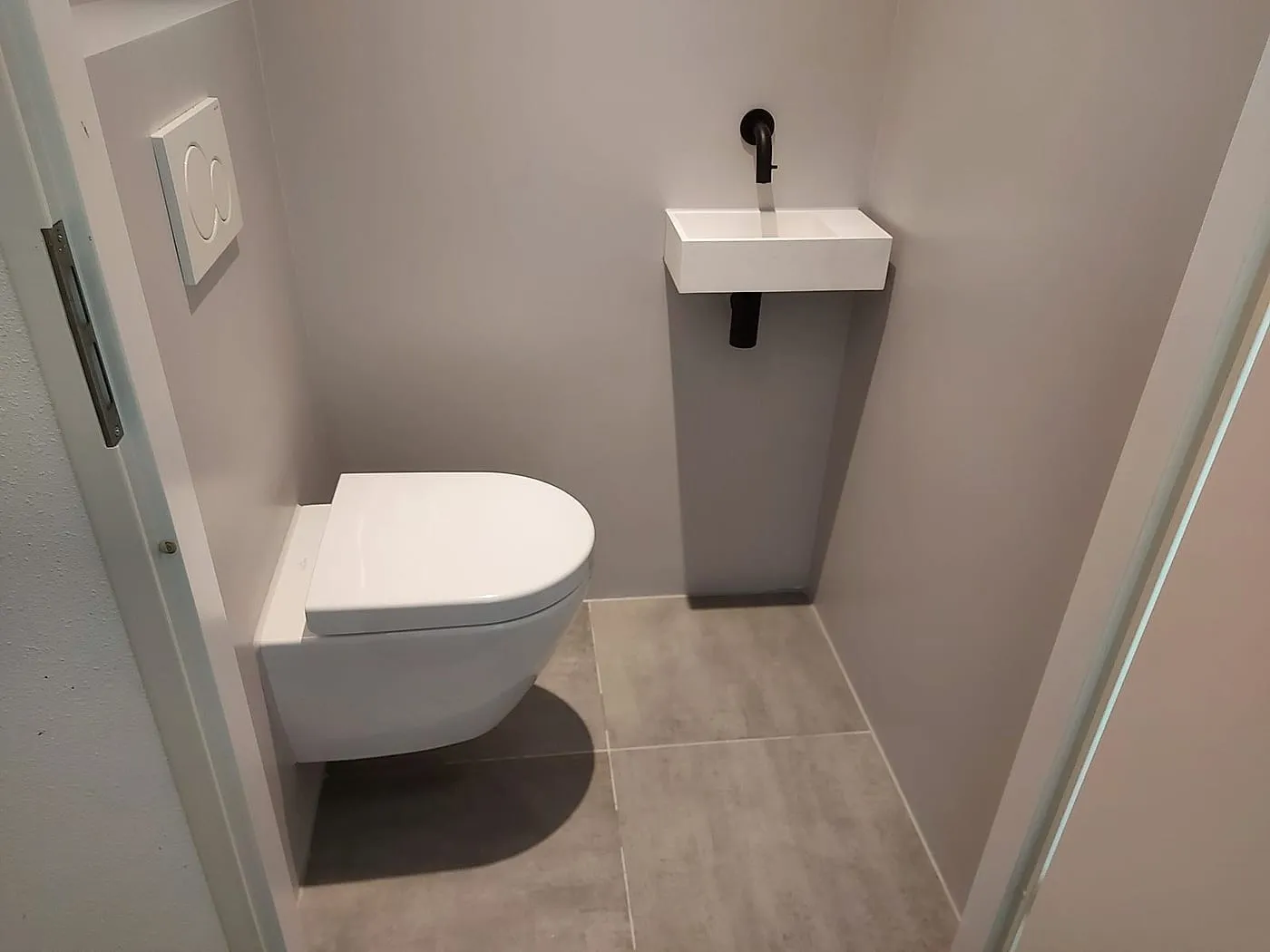 Hangtoilet met fontein op een gestucte sokkel na de renovatie — toiletrenovatie in Korrewegwijk door BontBouw