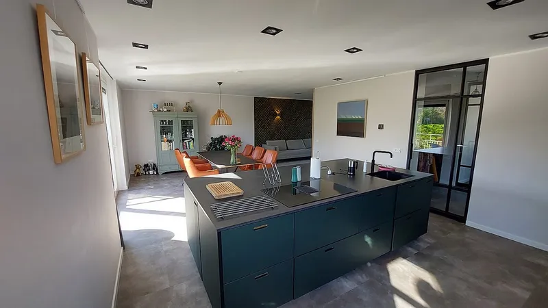 Kookeiland in donkergroen met betonlook werkblad — complete verbouwing in Eelderwolde door BontBouw
