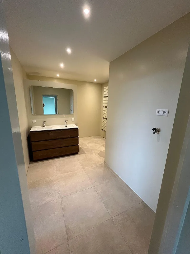 Ruime badkamer met travertinvloer — badkamerrenovatie in Apeldoorn door BontBouw