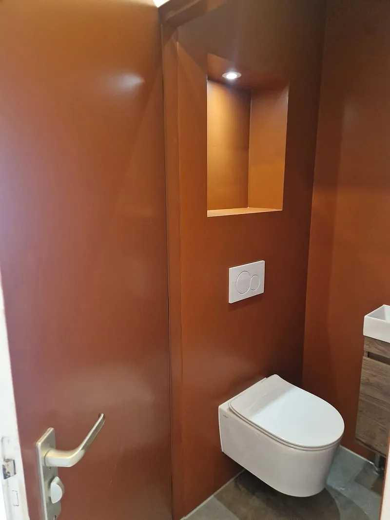 Verlichte nis in de terracotta wand — toiletrenovatie in Coendersborg door BontBouw