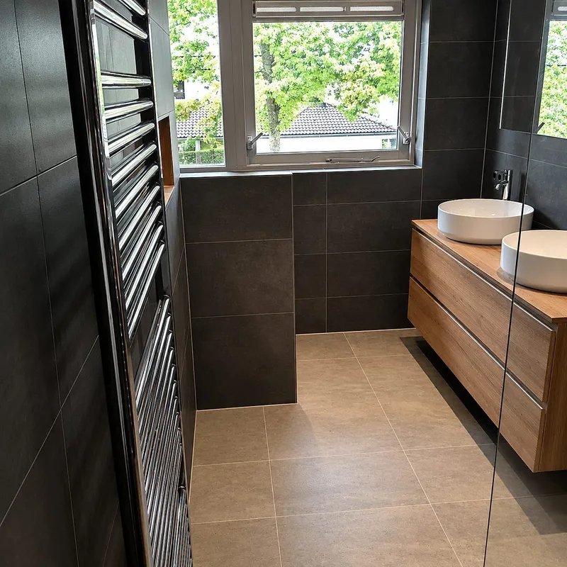 Chromen handdoekradiator naast houten wastafelmeubel — badkamerrenovatie in Kropswolde door BontBouw