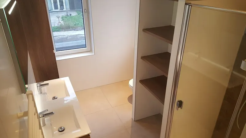 Dubbele wastafel met spiegelverlichting en open kast — badkamerrenovatie in Hoogezand door BontBouw