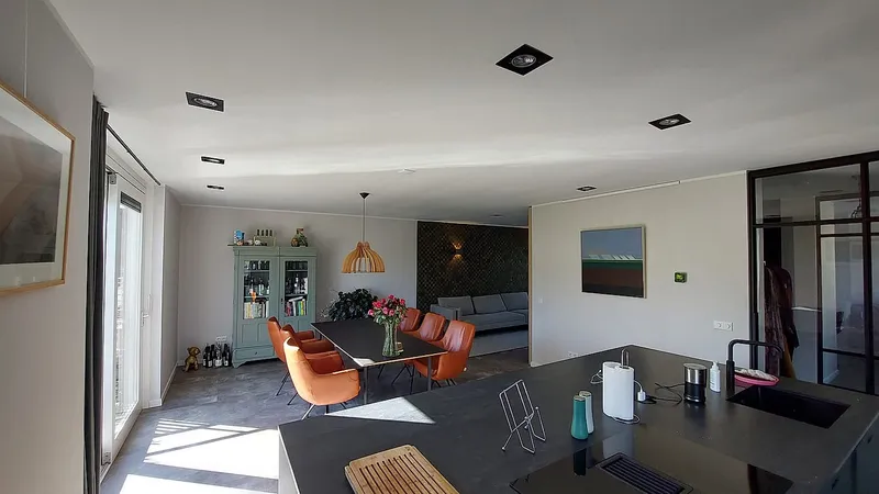 Eethoek met oranje stoelen en houten hanglamp — complete verbouwing in Eelderwolde door BontBouw