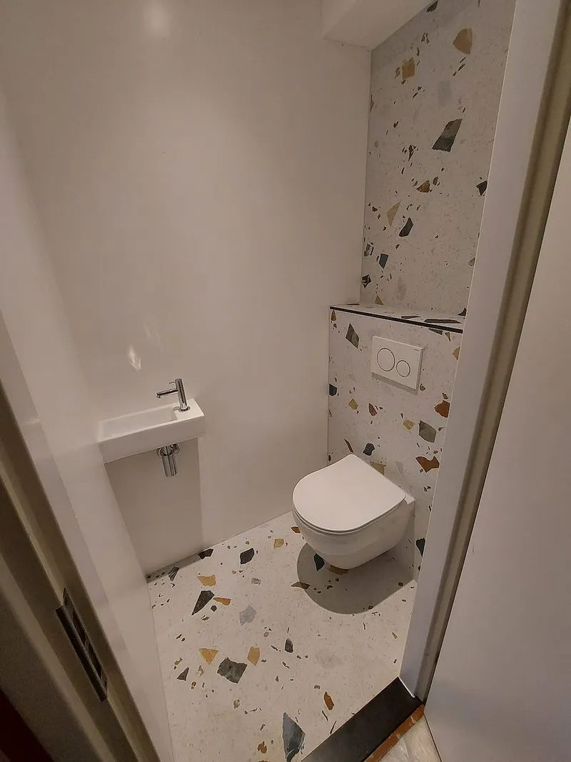 Fonteintje naast terrazzo vloer — toiletrenovatie in Schildersbuurt door BontBouw