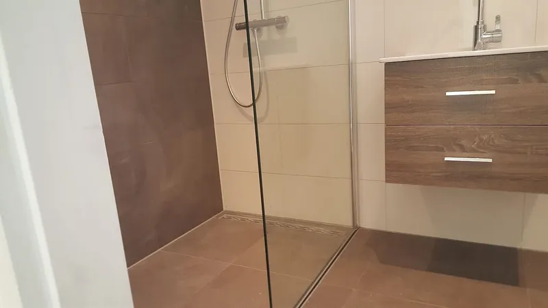 Inloopdouche met glazen wand en douchegoot in de vloer — badkamerrenovatie in Peize door BontBouw