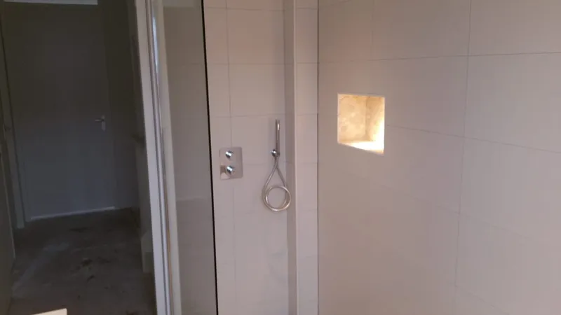 Inloopdouche met verlichte nis en inbouwthermostaatkraan — badkamerrenovatie in Haren door BontBouw