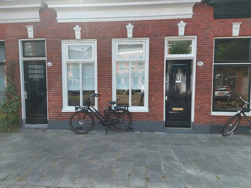 Witte kozijnen naast zwarte voordeur — schilderwerk in Korrewegwijk door Bontbouw