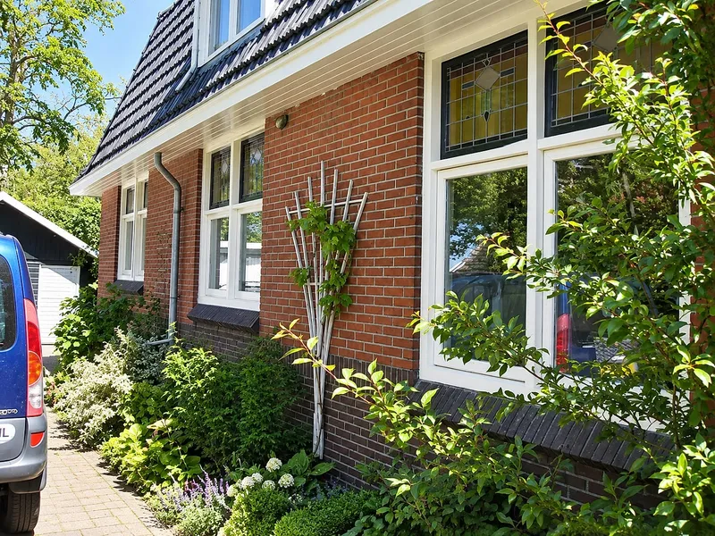 Zijgevel met witte kozijnen en glas in lood bovenlichten — schilderwerk in Groningen door BontBouw