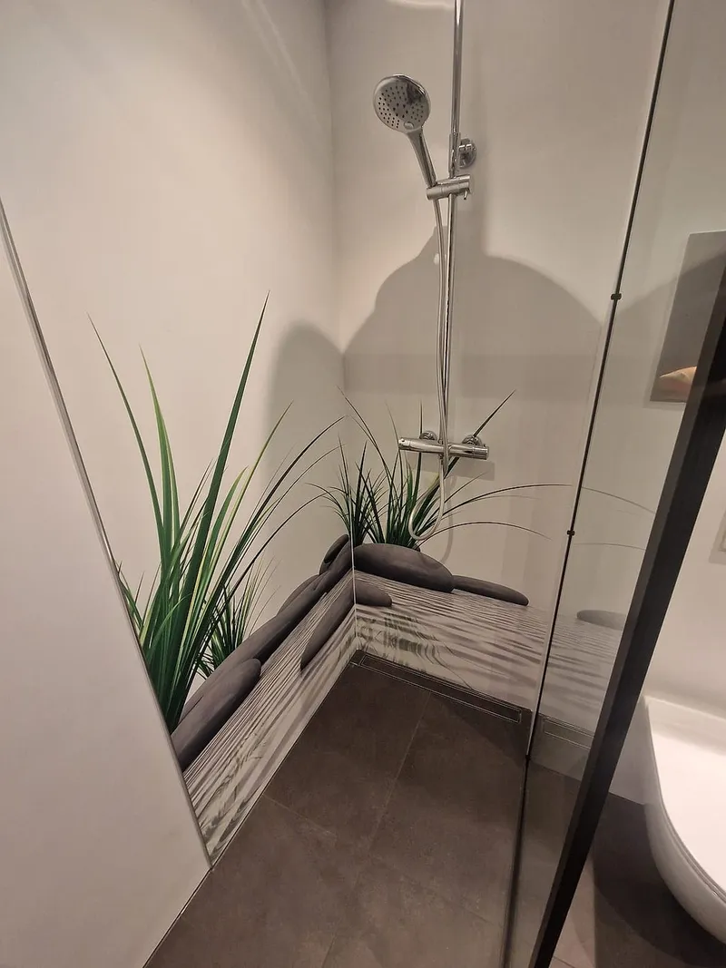 Douchekraan en handdouche tegen de fotowand in de inloopdouche — badkamerrenovatie in De Hunze door BontBouw