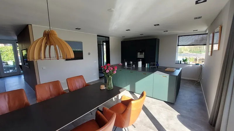 Eettafel en keuken met stalen taatsdeur — complete verbouwing in Eelderwolde door BontBouw