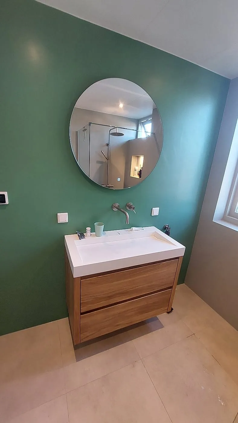 Eiken meubel met ronde spiegel groene wand — badkamerrenovatie in Sauwerd door BontBouw