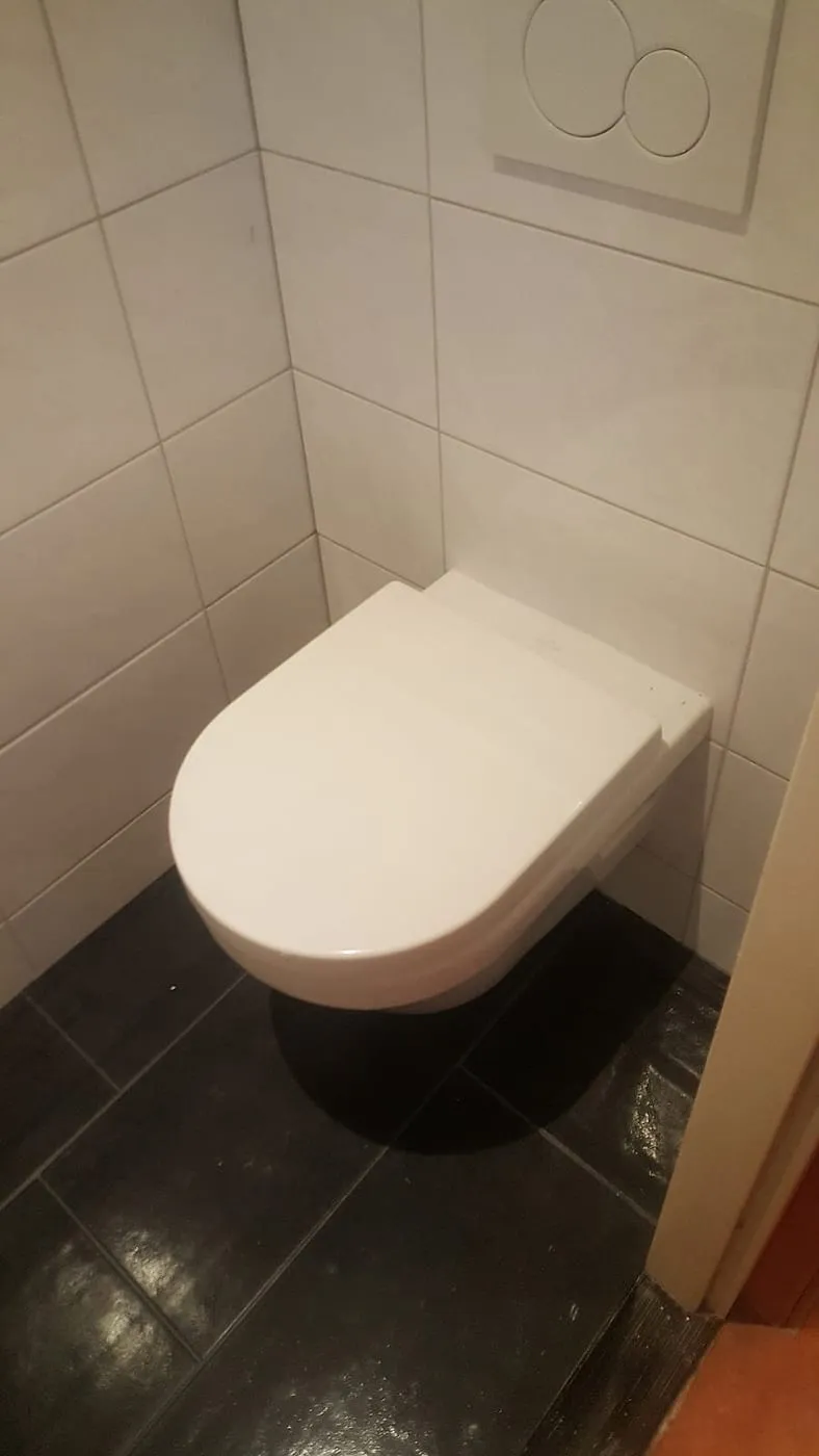 Hangend toilet op antracieten vloertegels — toiletrenovatie in Groningen door BontBouw