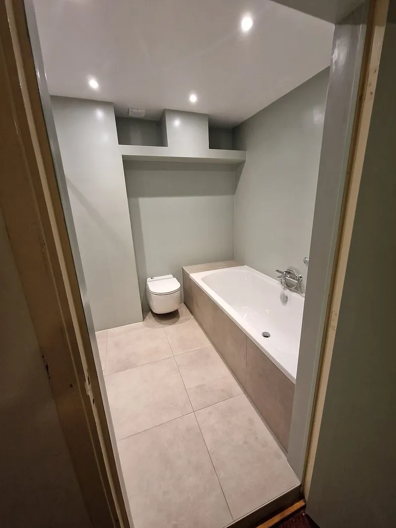 Ligbad met hangend toilet in de nis — badkamerrenovatie in Corpus den Hoorn door BontBouw