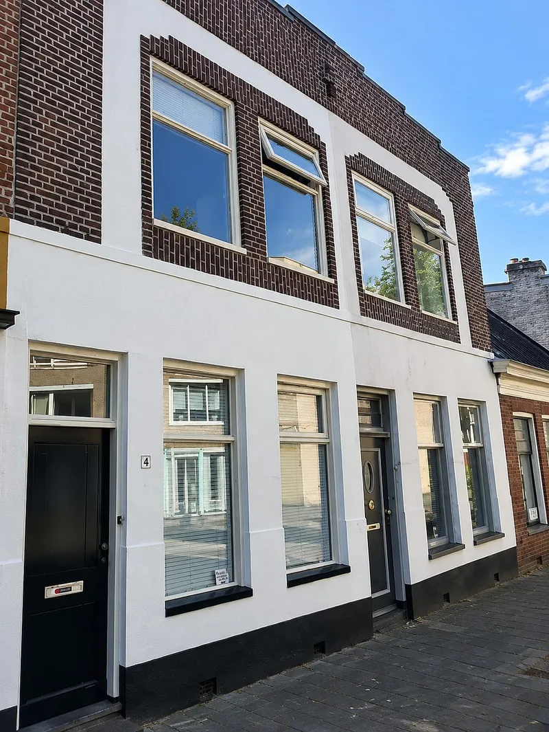 Schipperswoning met witte gevel en bruin metselwerk rond ramen — schilderwerk in Groningen door BontBouw