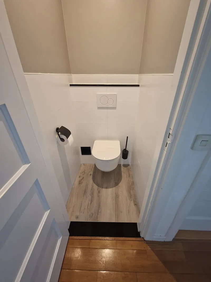Toilet met houtlook vloer en rolhouder — toiletrenovatie in Korrewegwijk door BontBouw