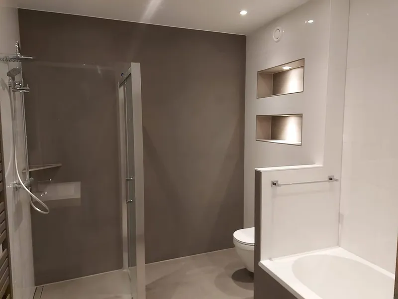 Verlichte nissen boven het ligbad — badkamerrenovatie in Schildersbuurt door BontBouw