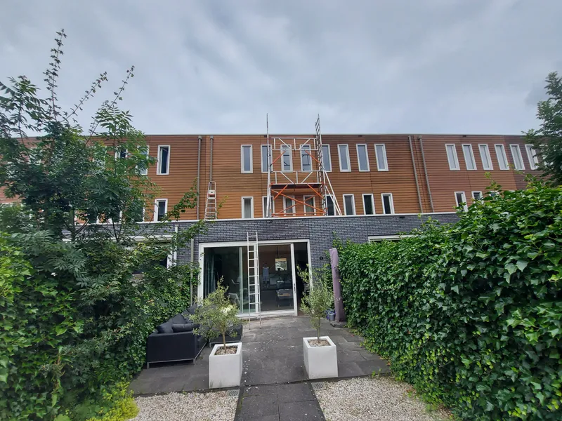 Achtergevel met rolsteiger gezien vanuit de tuin — schilderwerk in Groningen door BontBouw