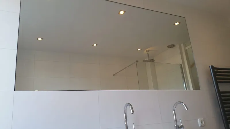 Brede spiegel met inbouwspots boven de dubbele wastafel — badkamerrenovatie in Haren door BontBouw
