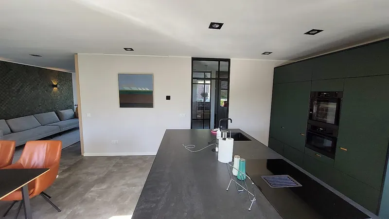 Donkergroene keukenwand met inbouwapparatuur — complete verbouwing in Eelderwolde door BontBouw
