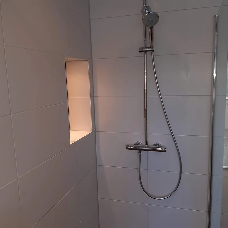 Douchehoek met verlichte nis — badkamerrenovatie in Coendersborg door BontBouw