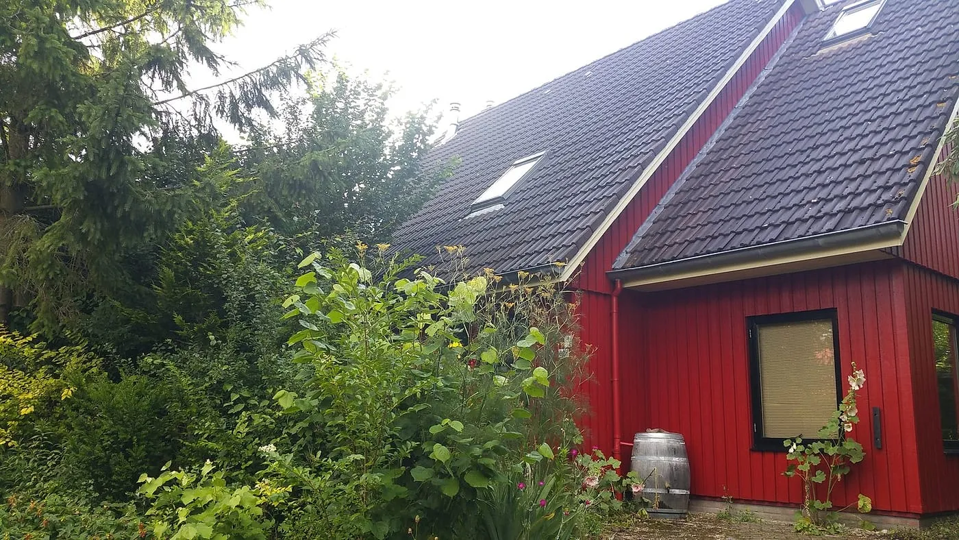 Geschilderde rode zijgevel met lichte boeiboord na het werk — schilderwerk in Beijum door BontBouw