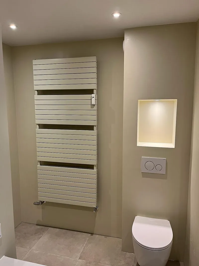 Handdoekradiator en verlichte nis naast het hangtoilet — complete verbouwing in Apeldoorn door BontBouw