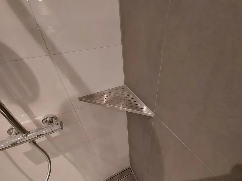 Rvs hoekplanchet in de douche — badkamerrenovatie in Schildersbuurt door BontBouw