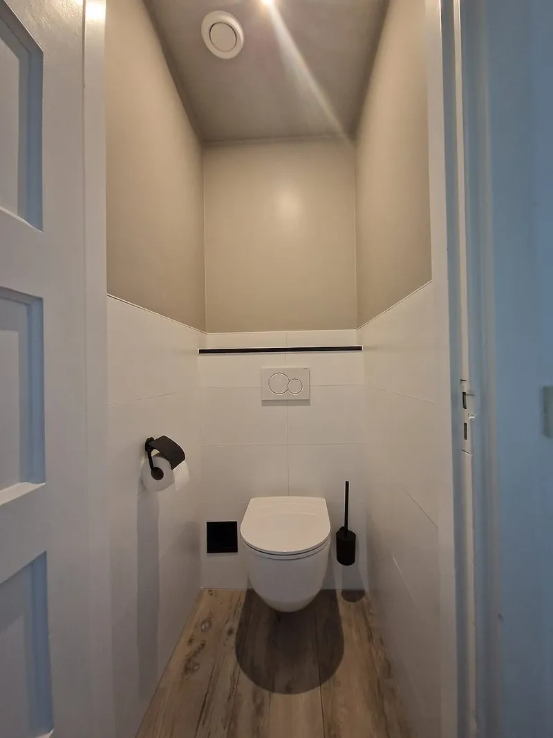 Toilet met hoge wand in zandtint — toiletrenovatie in Korrewegwijk door BontBouw