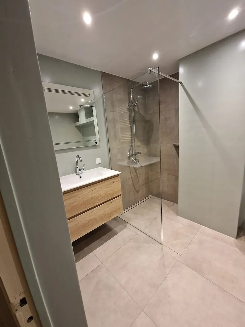 Wastafelmeubel in houtlook naast de douche — badkamerrenovatie in Corpus den Hoorn door BontBouw