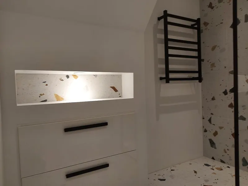 Zwarte handdoekradiator naast de douche — badkamerrenovatie in Schildersbuurt door BontBouw