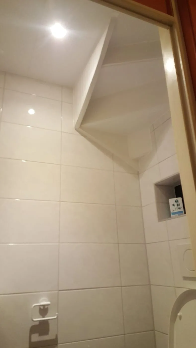 Betegelde schuine wand onder de trap — toiletrenovatie in Groningen door BontBouw