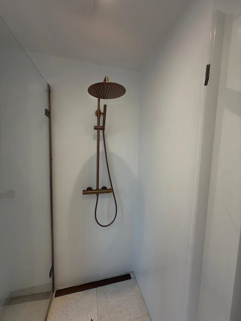 Regendouche in geborsteld koper — badkamerrenovatie in Beijum door BontBouw