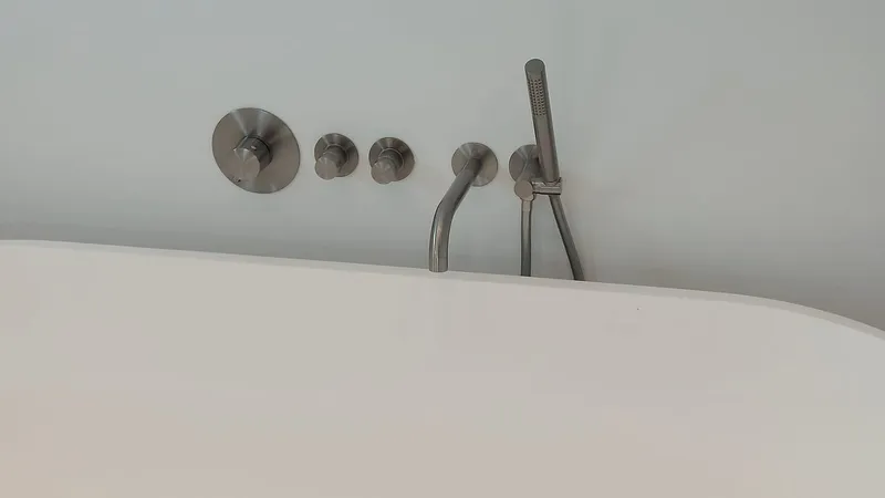 Rvs inbouwkraan met handdouche bij het vrijstaande bad — badkamerrenovatie in Eelderwolde door BontBouw