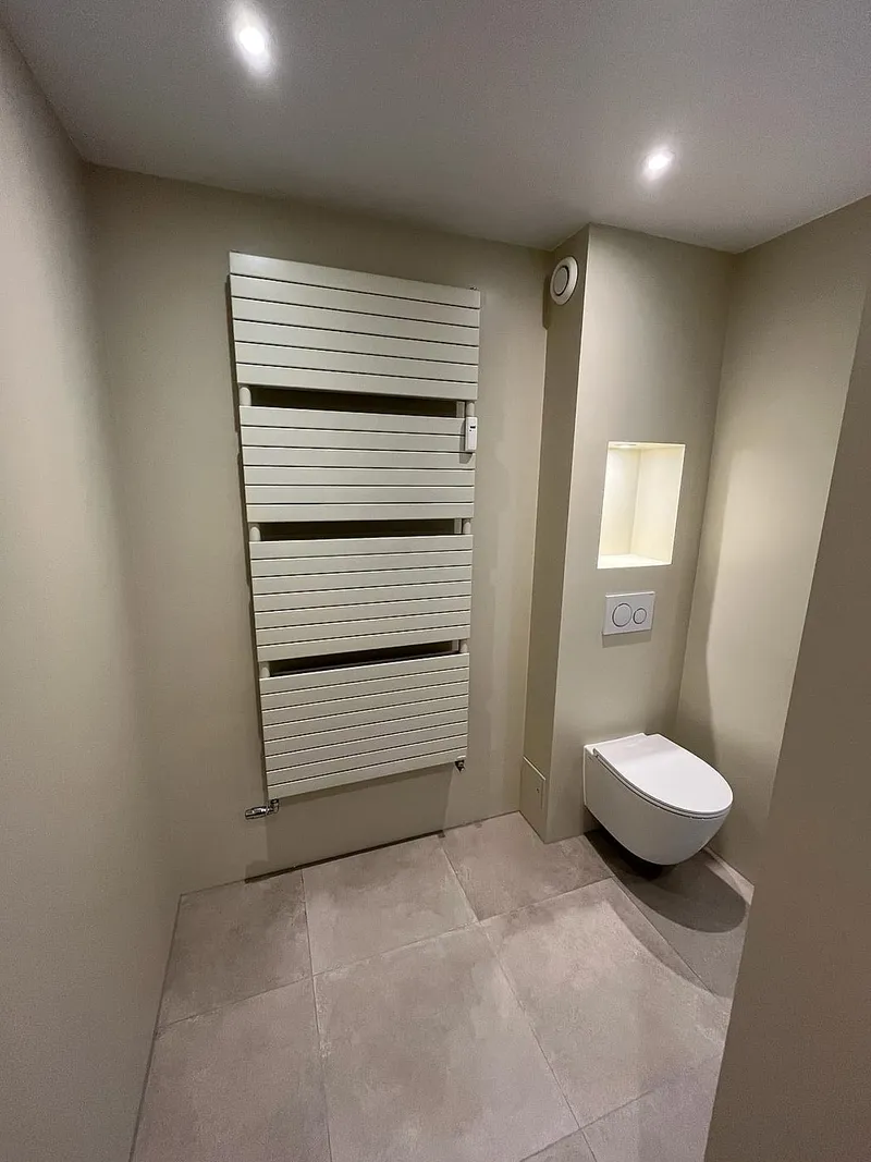 Hangtoilet met verlichte nis en handdoekradiator — complete verbouwing in Apeldoorn door BontBouw
