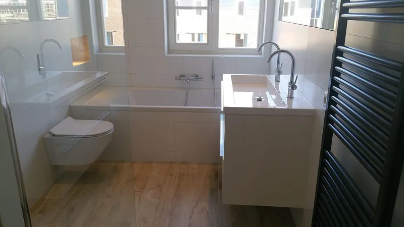 Ligbad dubbele wastafel en hangtoilet op houtlook tegels — badkamerrenovatie in Haren door BontBouw
