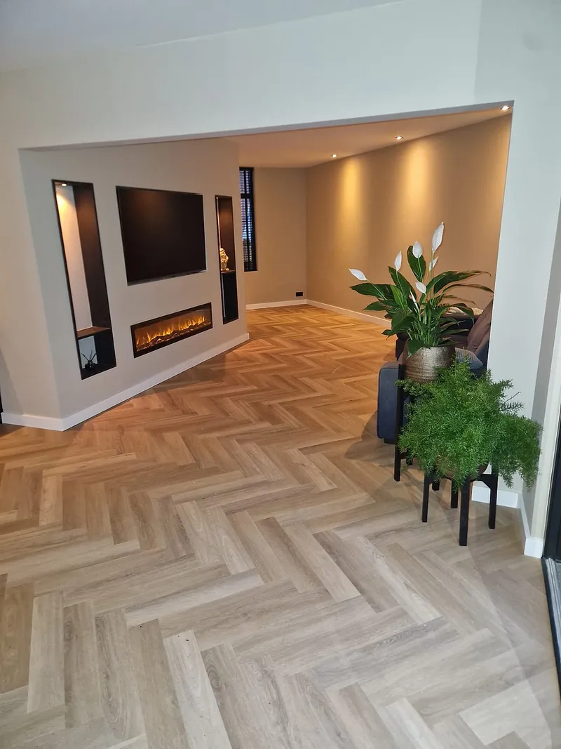 Haardwand met televisie en visgraatvloer — complete verbouwing in Beijum door BontBouw