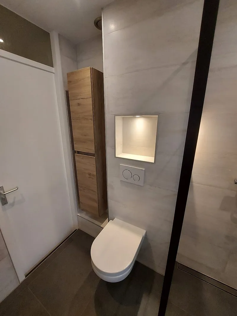 Hoge kast in houtlook naast het toilet — badkamerrenovatie in Hoogkerk door BontBouw