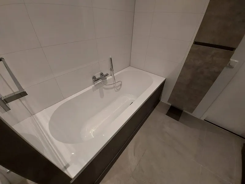 Ligbad met chromen badmengkraan — badkamerrenovatie in Schildersbuurt door BontBouw