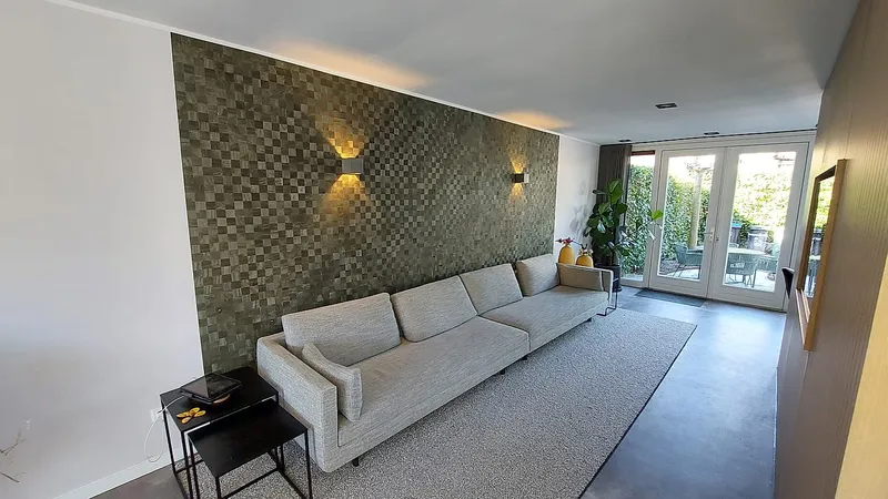 Mozaiekwand met wandlampen in de woonkamer — complete verbouwing in Eelderwolde door BontBouw