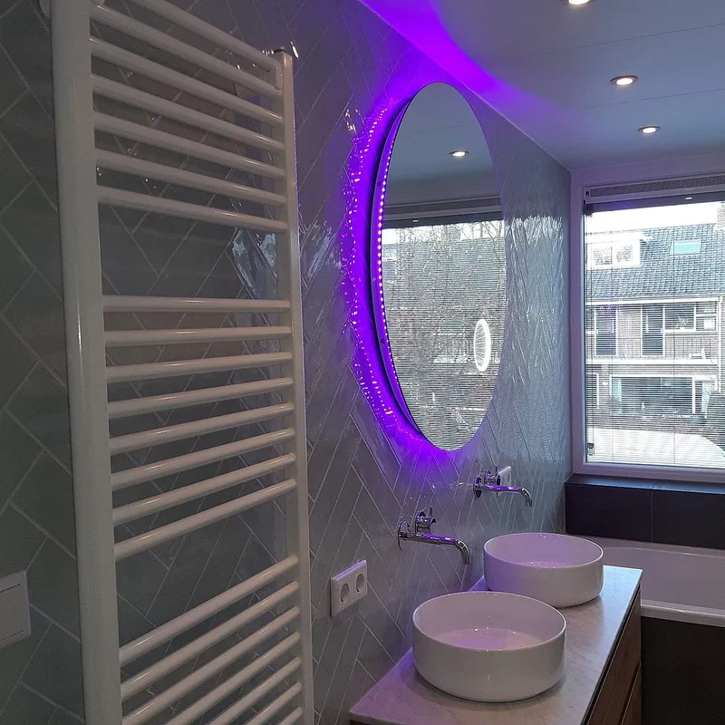 Ronde spiegel met gekleurde verlichting — badkamerrenovatie in Coendersborg door BontBouw