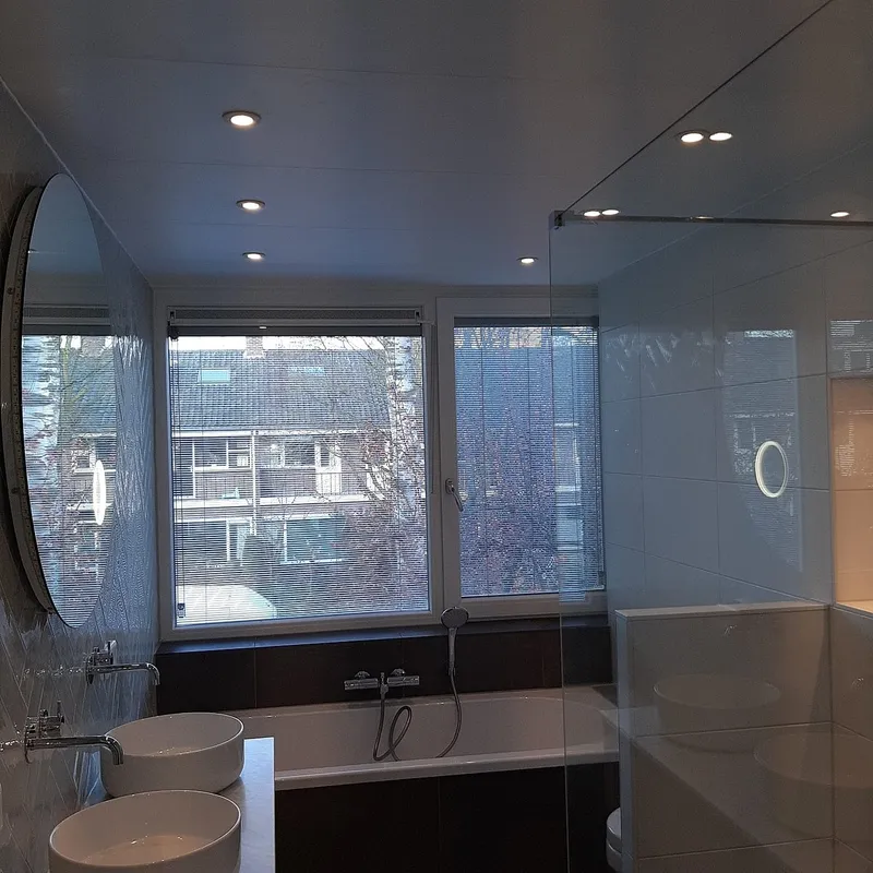 Badkamer met ligbad en glazen douchewand — badkamerrenovatie in Coendersborg door BontBouw