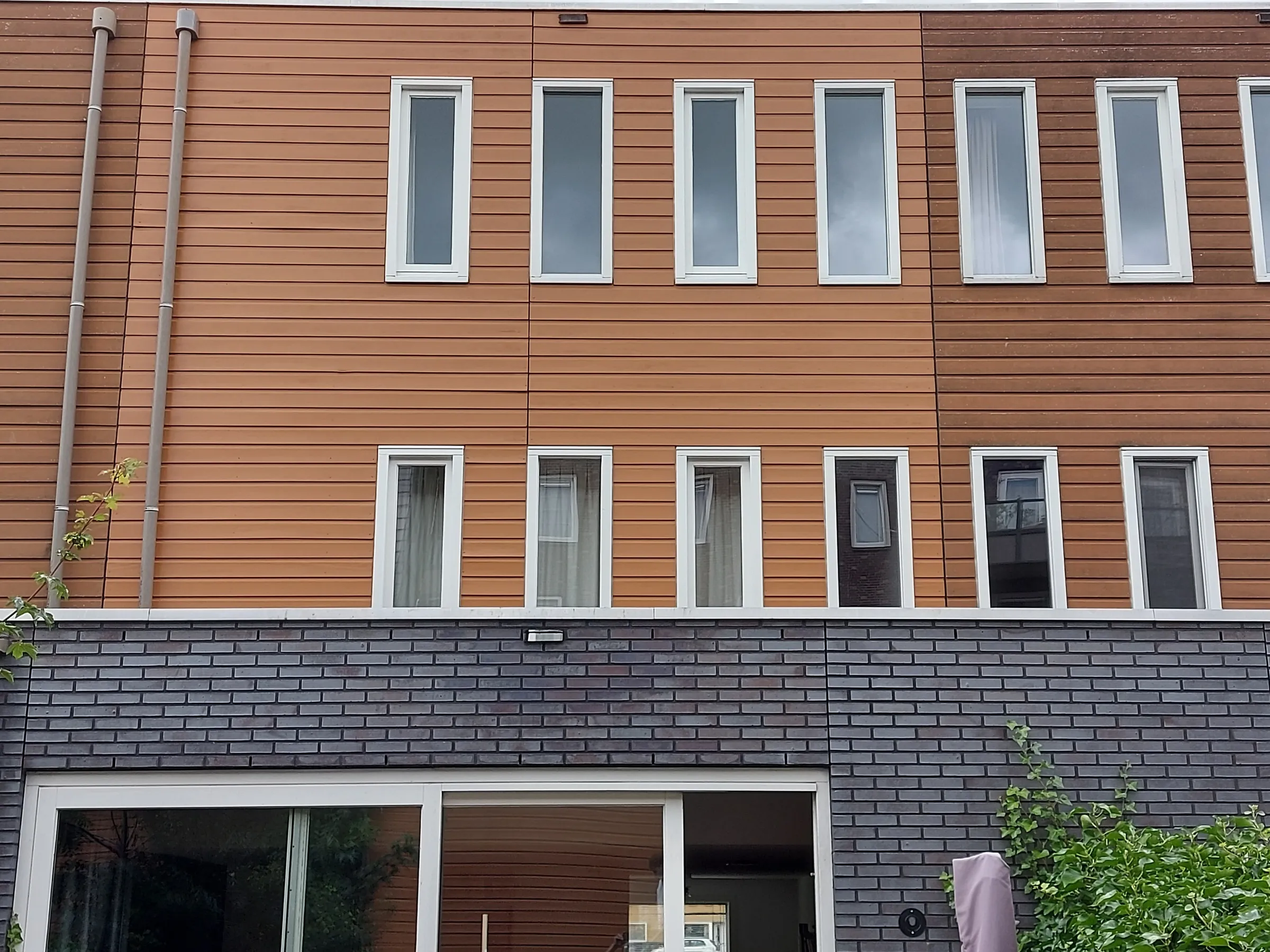 Achtergevel met houten gevelbekleding in oranjebruine tint na het werk — schilderwerk in Groningen door BontBouw