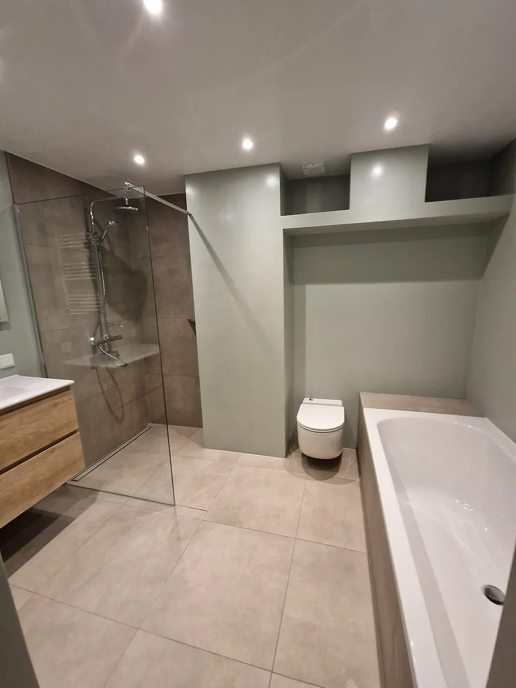 Ligbad met hangend toilet na de renovatie — badkamerrenovatie in Corpus den Hoorn door BontBouw
