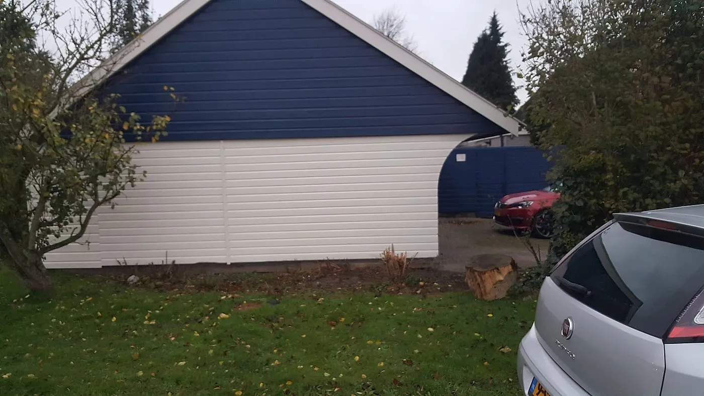 Strak blauwe topgevel met roomwitte houten gevelbekleding na het werk — schilderwerk in Euvelgunne door BontBouw
