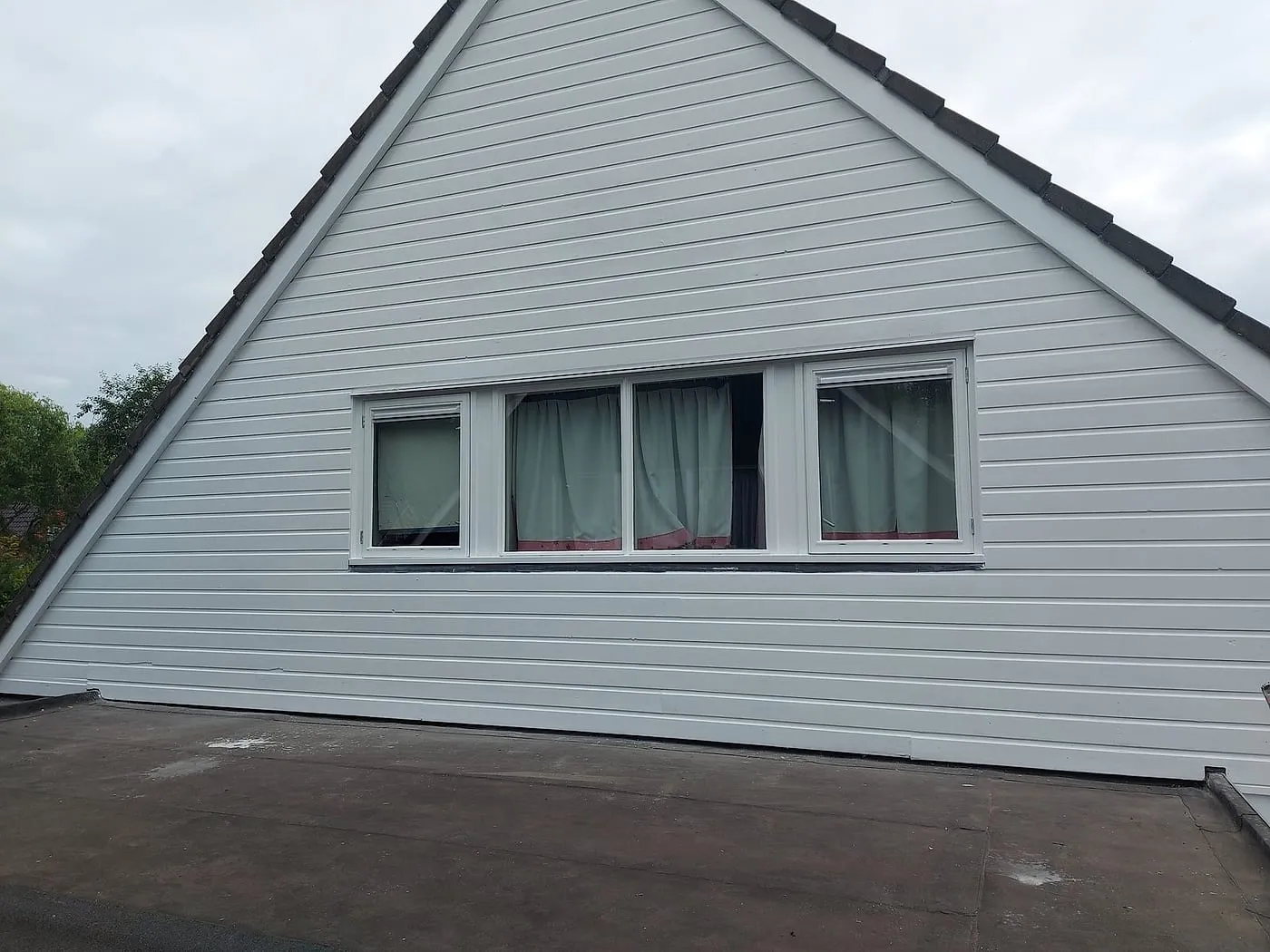 Strak witte houten topgevel met geschilderde kozijnen na het werk — schilderwerk in Harkstede door BontBouw