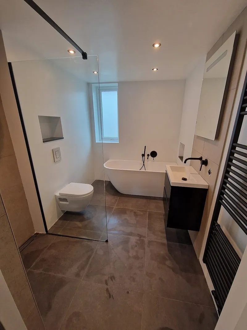 Badkamer met vrijstaand bad en inloopdouche — badkamerrenovatie in Ulgersmaborg door BontBouw