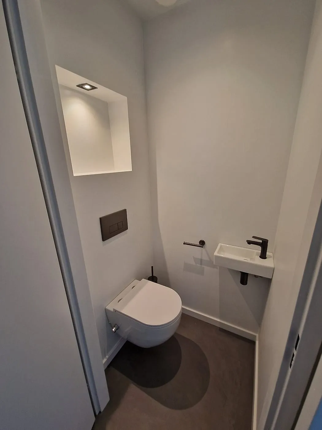 Wit toilet met verlichte nis na de renovatie — toiletrenovatie in Roden door BontBouw